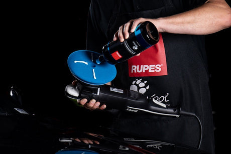 Anson PDR technician applying RUPES D-A COARSE polishing compound to a blue foam pad on a BigFoot dual action polisher.