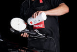Anson PDR technician applying UNO PURE polish to a white Rupes D-A ULTRA-FINE foam pad on a dual action polisher.