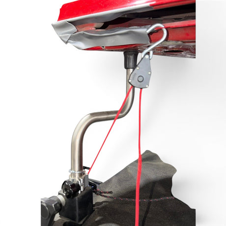 Anson PDR clamp-style rope ratchet with red cord attached to a car hood stand for dent repair.
